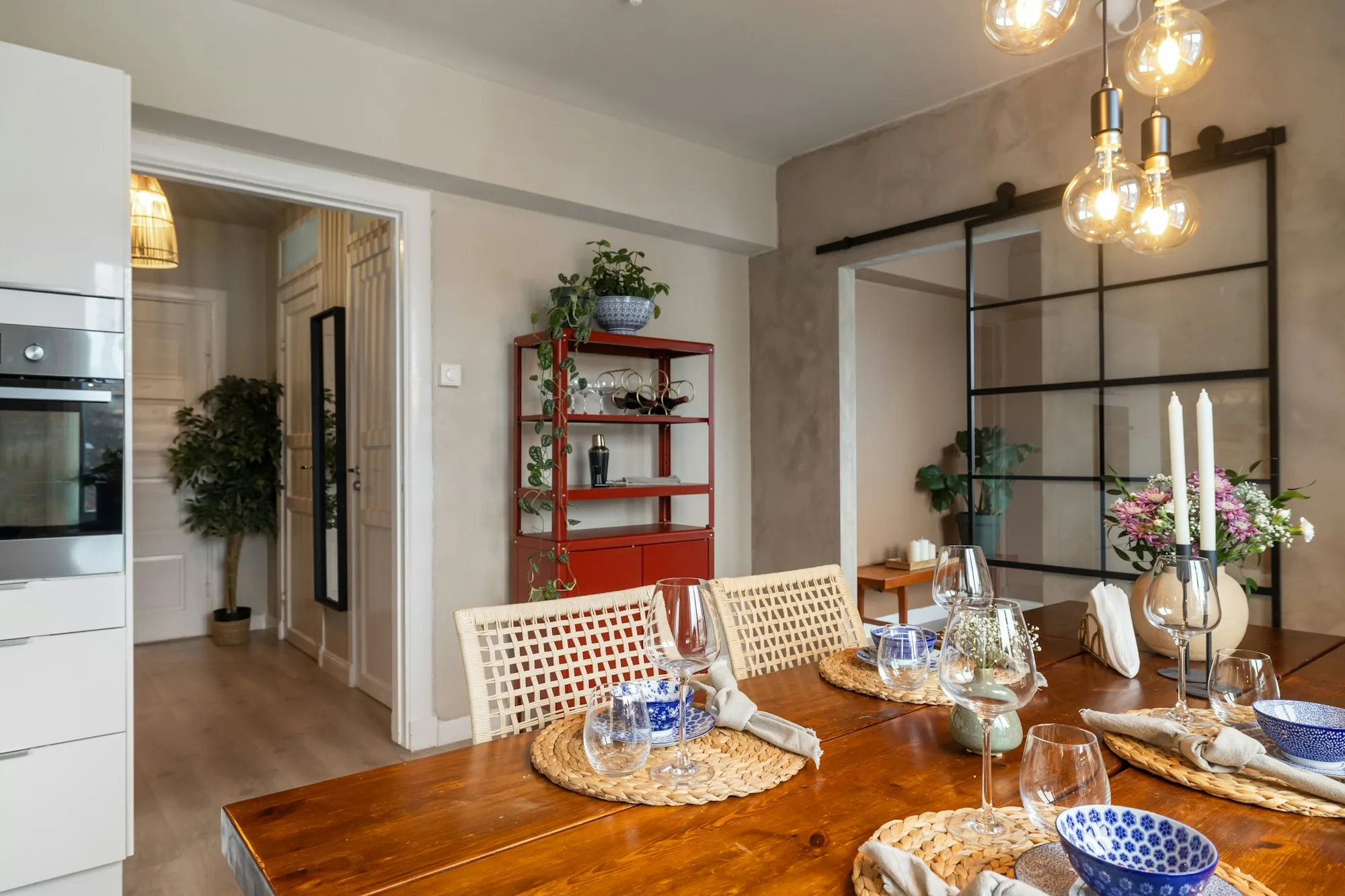 Set dining table with candles in a warm open-plan room