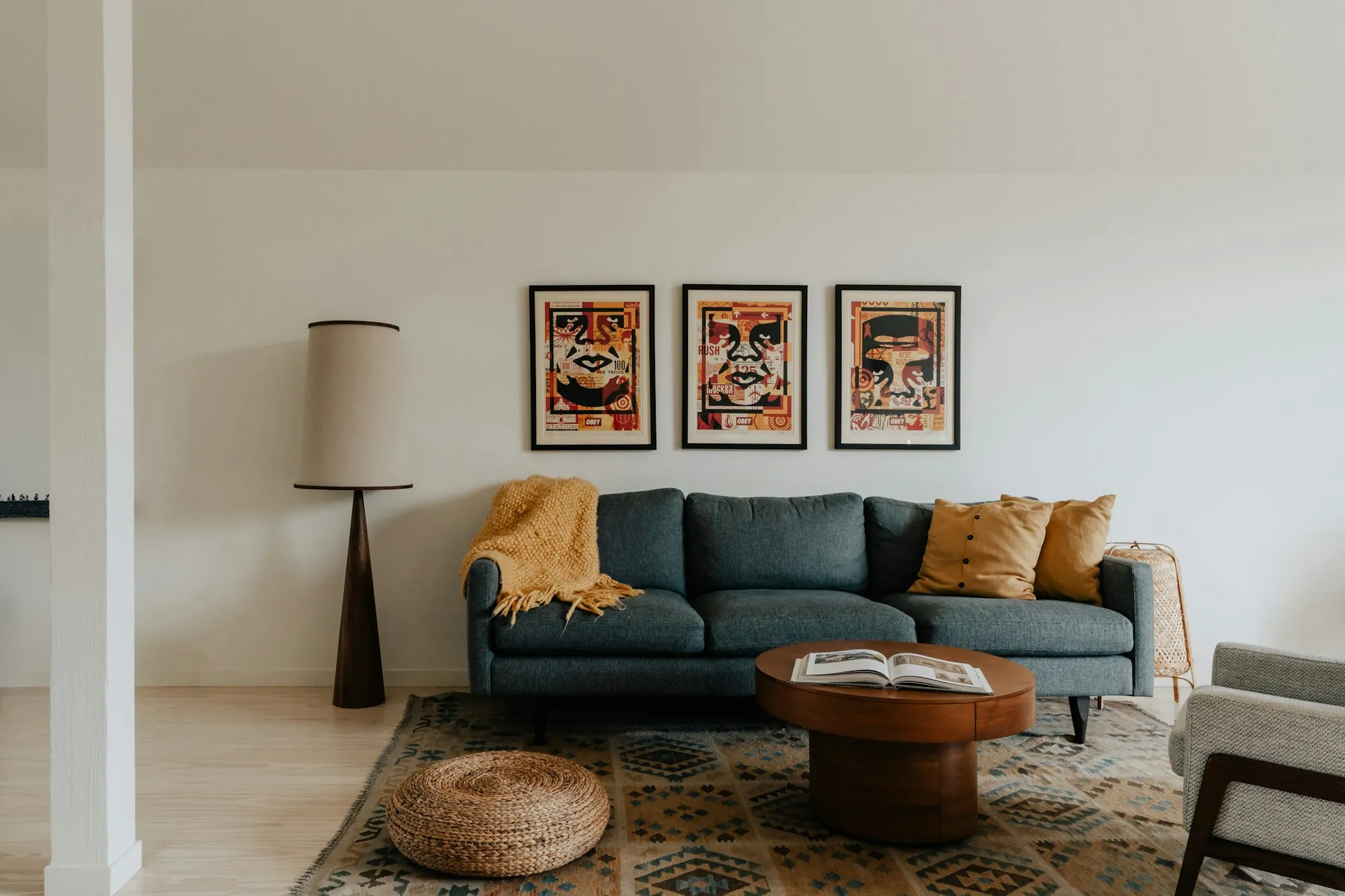 Living room with a teal sofa and three framed prints