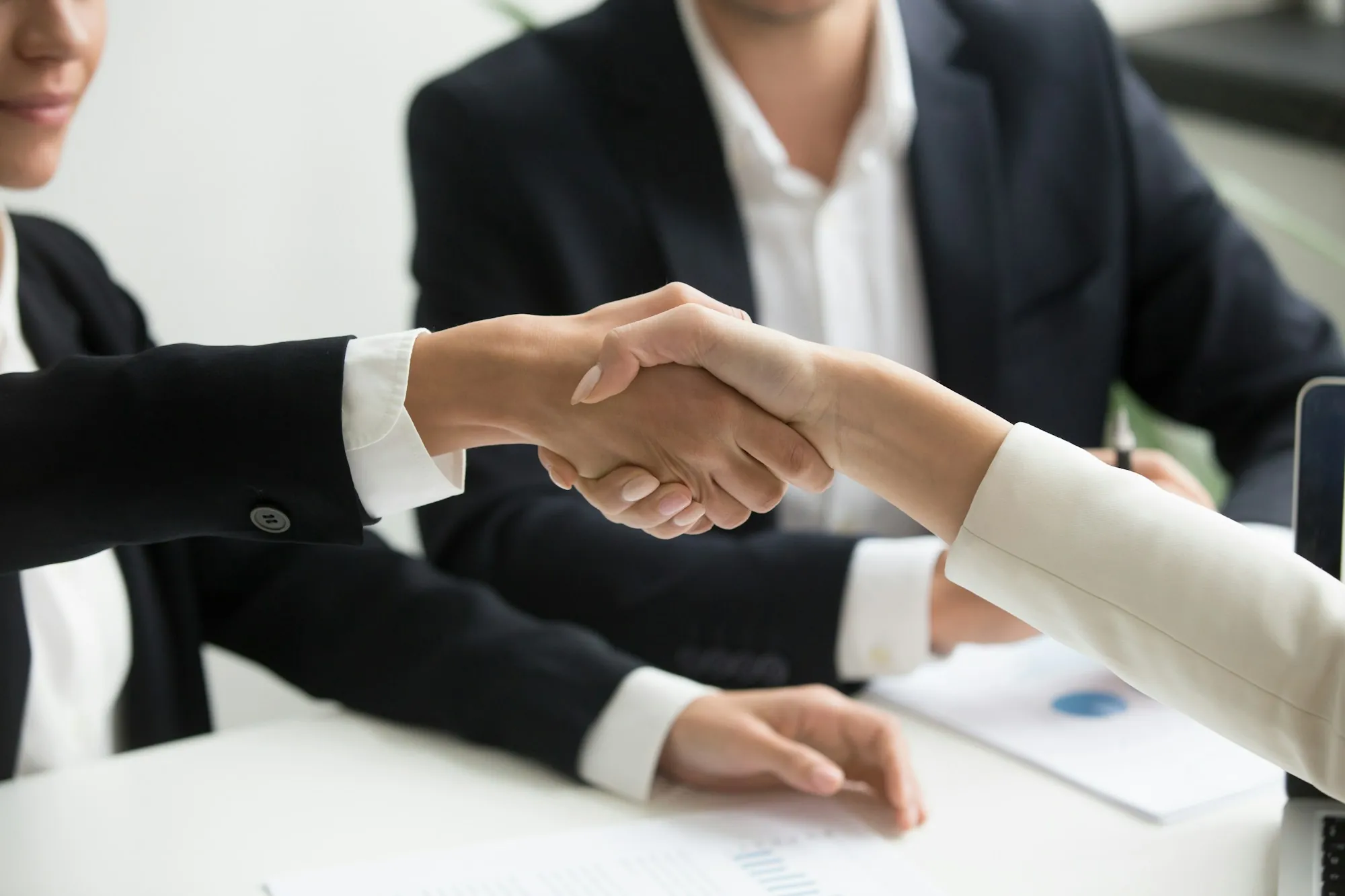 Handshake over a desk with papers